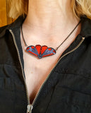 cinnabar moth goth moth necklace being worn by a woman in a black zip up top