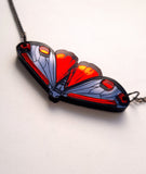 close up of the sun shining off the mirror surface of the goth moth cinnabar moth necklace