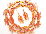 a pair of goldfish earrings surrounded by acrylic goldfish charms