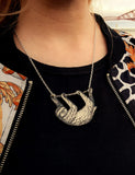 sloth necklace around a woman's neck