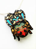 close up of the jumping spider necklace showing iridescent and mirrored detail