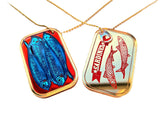 sardine necklace shown from both sides. One depicting the sardines in the open can, the other the face of the closed can