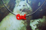 cunt necklace on top of a painting of two dogs